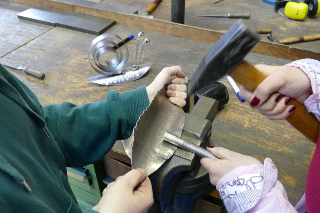 In der Metallwerkstatt: An einer Schnecke als Gartendeko wird gearbeitet
