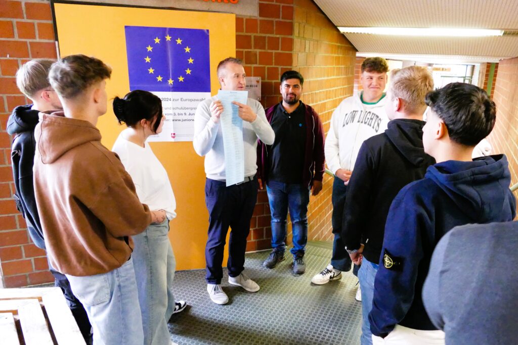 Politiklehrer Marek Hoffmann stellt den Stimmzettel für die Europawahl vor